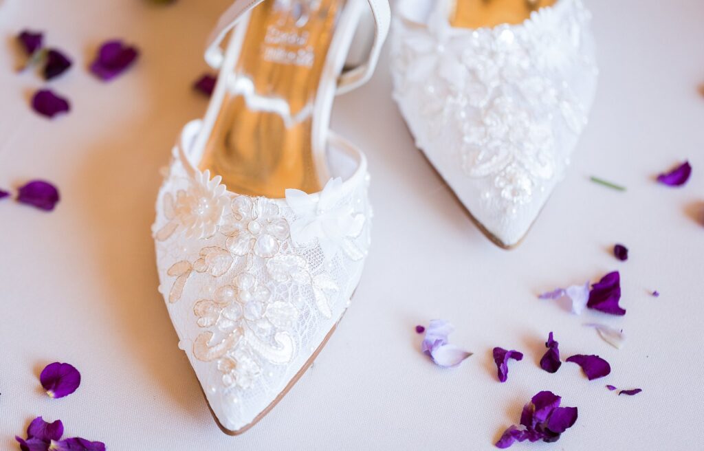 Chic bridal detail flatlays showcasing the bride's stunning high-heeled shoes with intricate beaded embellishments, captured at Judson Mill in downtown Greenville, South Carolina