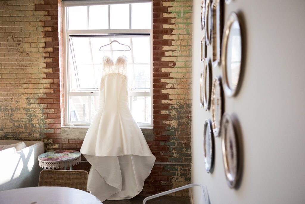 Chic and modern bride's dress featuring a plunging neckline, hanging in anticipation