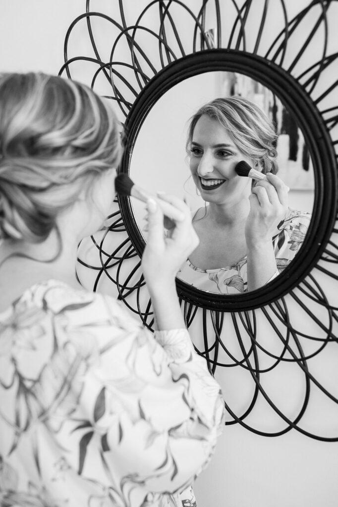 A skilled makeup artist enhances the bride's natural beauty, preparing her for the wedding festivities at Judson Mill, downtown Greenville, South Carolina.