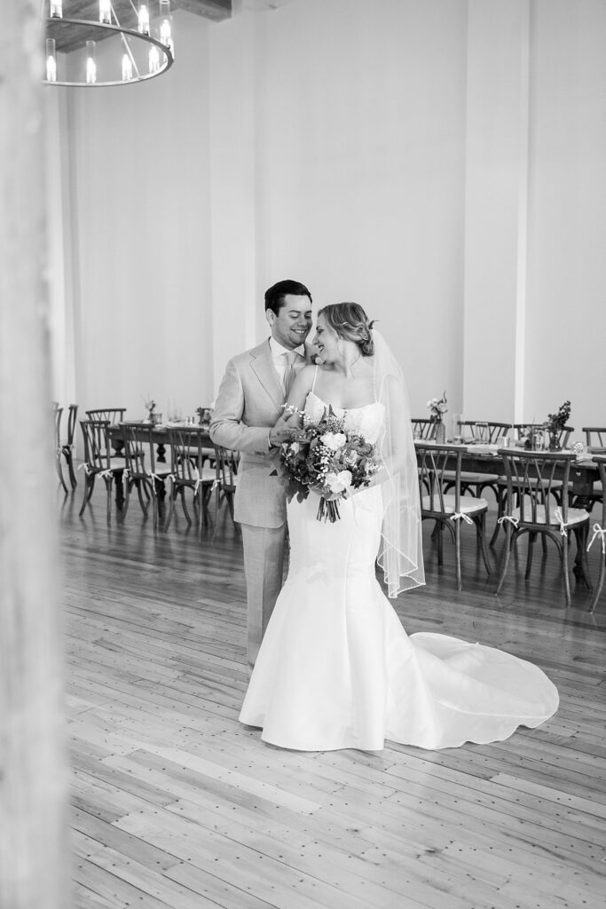 Elegant bride and groom stealing a glance at each other, bathed in the romantic atmosphere of Judson Mill's ceremony and reception area in downtown Greenville, South Carolina.