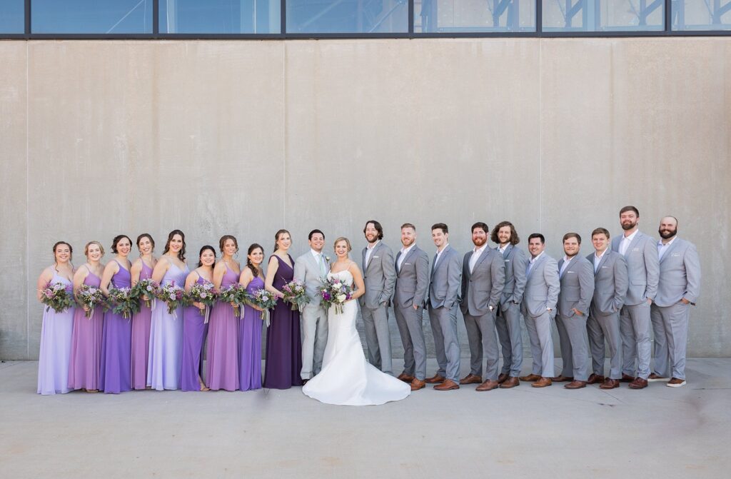 An elegant portrait session showcasing the beautiful bond between the bride, groom, and their supportive bridal party at the picturesque Judson Mill in downtown Greenville, South Carolina.