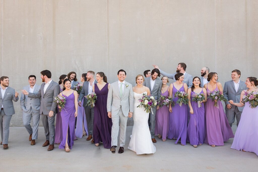 A picture-perfect moment of the bride and groom, along with their bridesmaids and groomsmen, against the industrial backdrop of Judson Mill in downtown Greenville, South Carolina.
