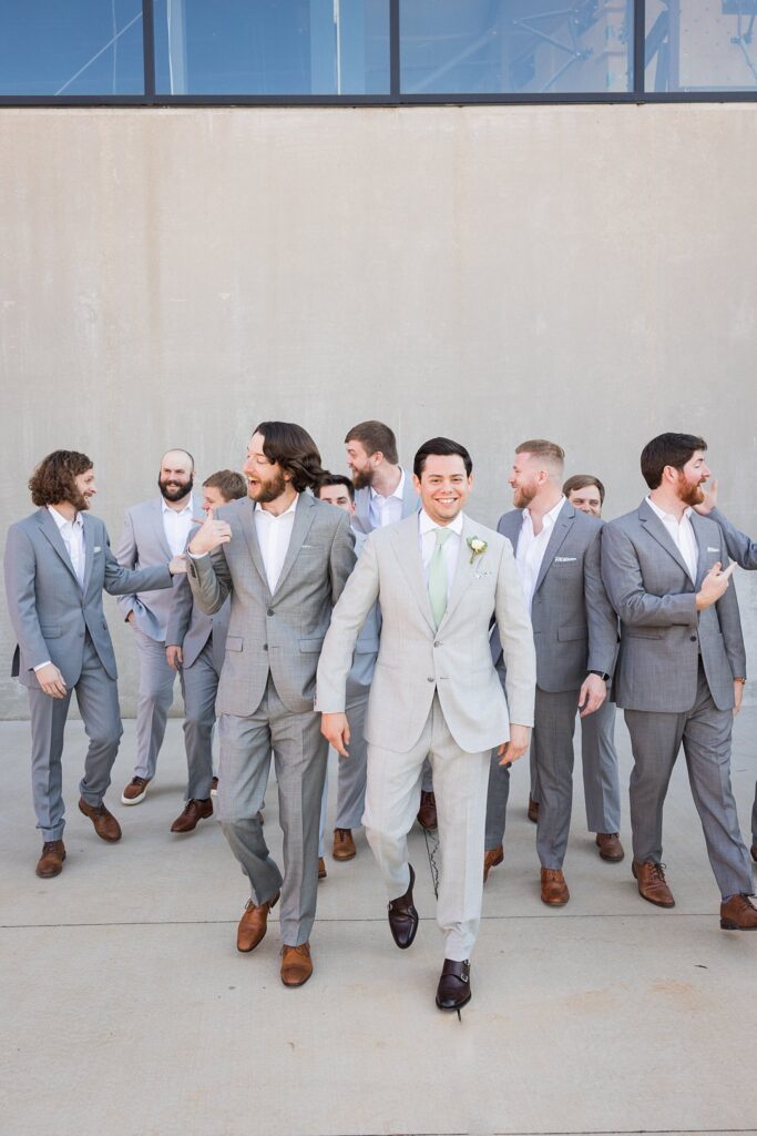 A heartwarming moment captured as the groom and his groomsmen stroll through the charming streets of downtown Greenville, South Carolina, with genuine smiles and a sense of excitement.