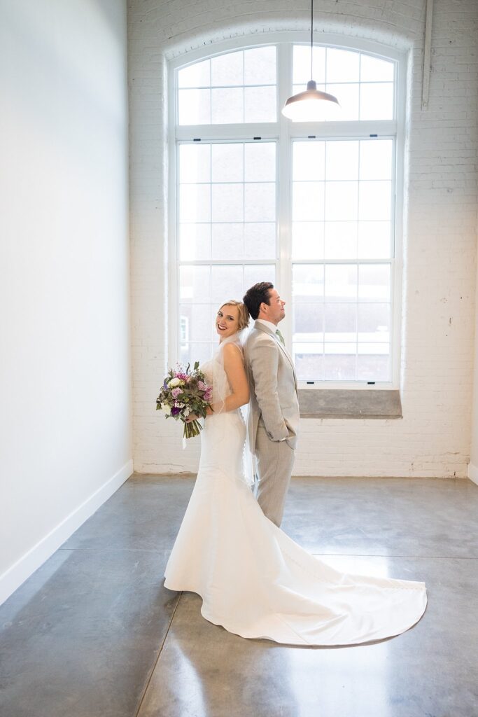 In this captivating wedding portrait, the couple's genuine love and joy shine through, creating a beautifully bright and airy atmosphere that perfectly reflects their special day at Judson Mill.