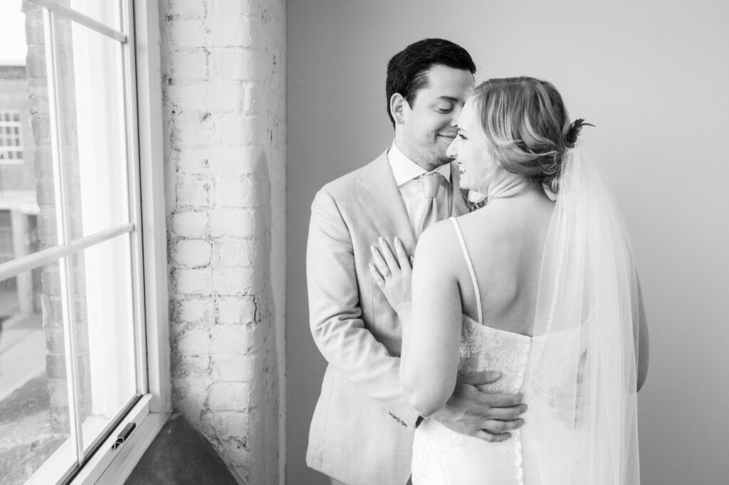 A captivating image showcasing the bride and groom's wedding portrait, filled with love, joy, and an ethereal brightness that beautifully captures the essence of their special day at Judson Mill.