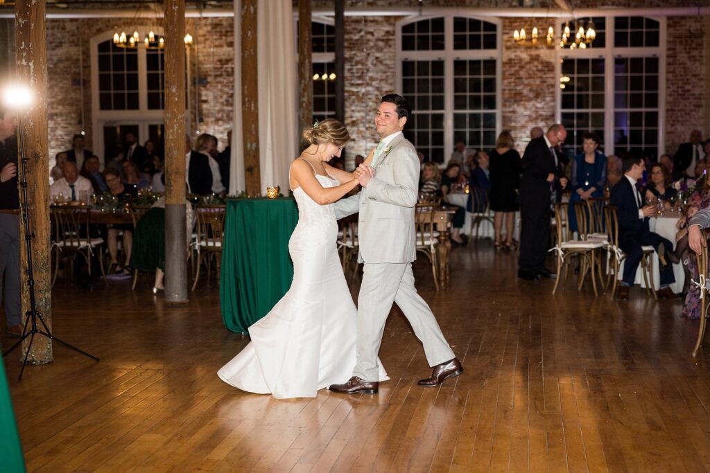 Surrounded by the enchanting ambiance of Judson Mill, the bride and groom share an intimate moment during their first dance, perfectly capturing the joy of their special day in Greenville, South Carolina.