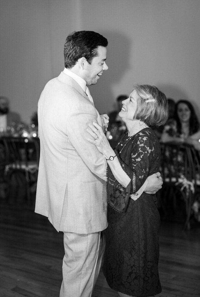 Emotions run high as the groom gracefully twirls his beaming mother across the dance floor during their first dance at Judson Mill, Greenville.