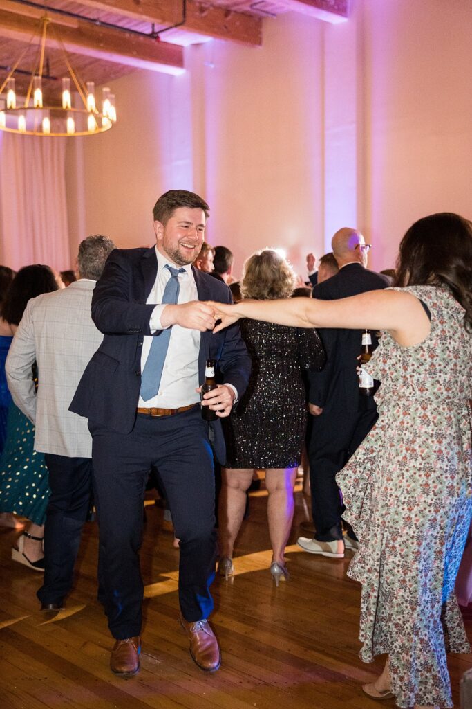 Vibrant dance floor filled with laughter and celebration at Judson Mill wedding