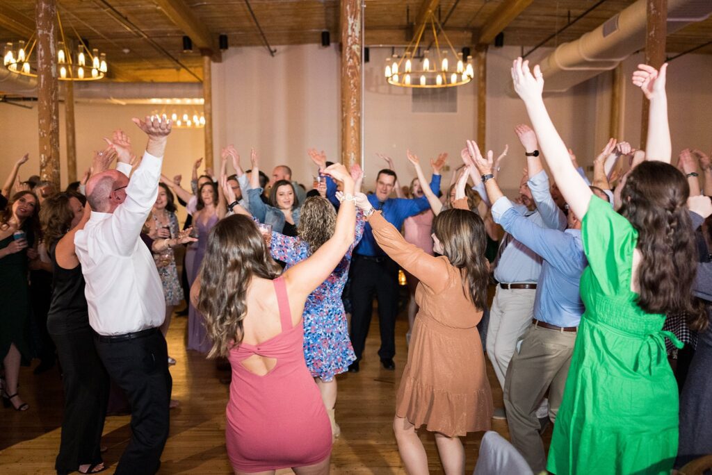 Bride and groom surrounded by friends as they dance the night away at their vibrant reception