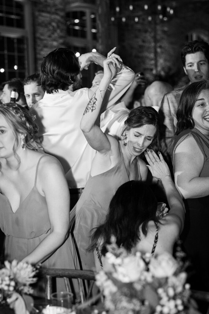 Bride and groom sharing a joyful moment while dancing at their lively reception
