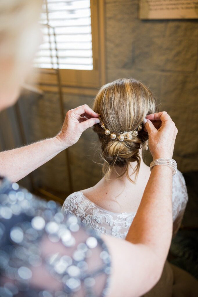 Bride's radiant smile as she adorns her earrings, capturing the anticipation of her special day, captured by Lace + Honey.