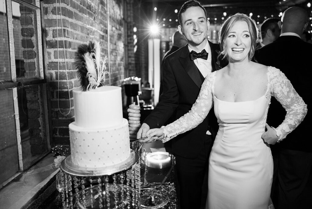 Couple's cake cutting moment at wedding, shot by Lace + Honey