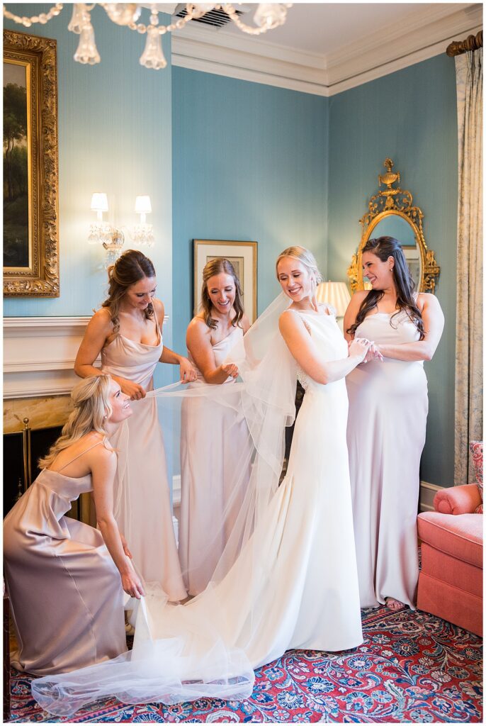 Bridesmaids helping bride into her dress
