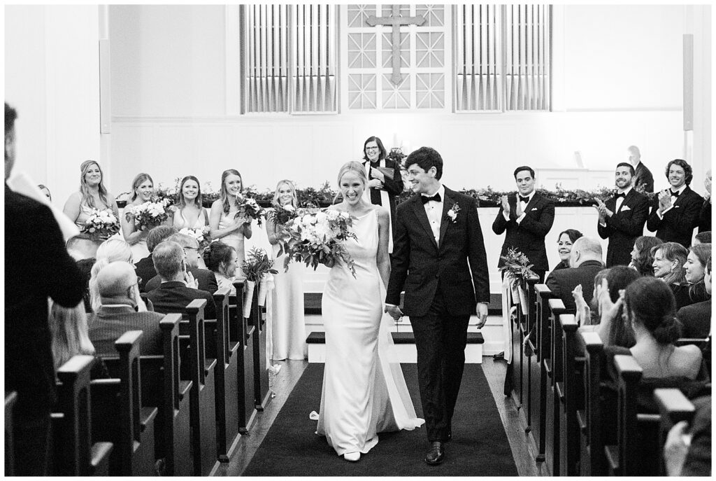 bride and groom happily married walking back up aisle