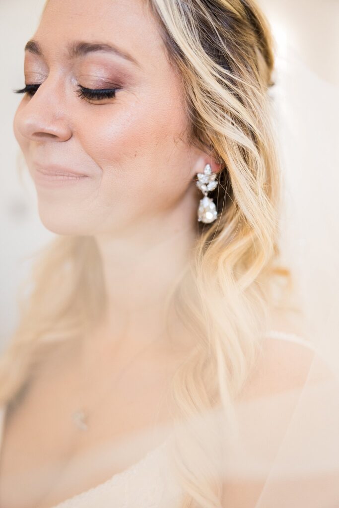 Captivating Bridal Beauty: Bride's portrait with earrings at South Wind Ranch - A stunning portrayal of the bride's glowing confidence.