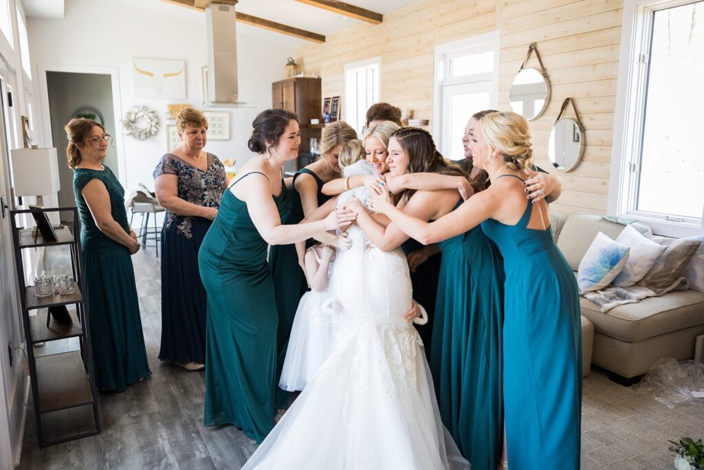 Bridesmaids' Joy: First look with fully dressed bride at South Wind Ranch - A candid display of excitement and admiration among the bridal party