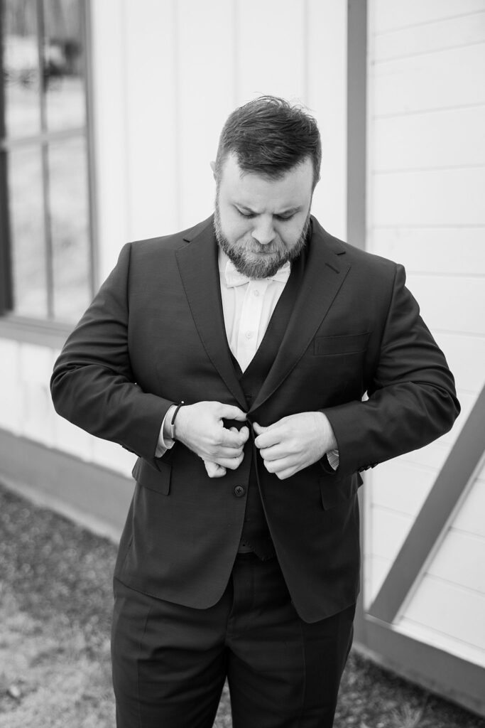 Groom's Classic Style: Adjusting his tie at South Wind Ranch, Travelers Rest SC - Ensuring every detail is perfect before the ceremony.