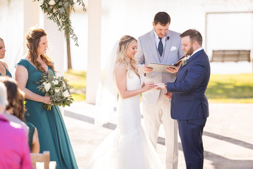 Exchanging Vows: Bride and Groom's Tender Ring Moment at the Ceremony - The exchange of rings, sealing their promise to love and cherish each other